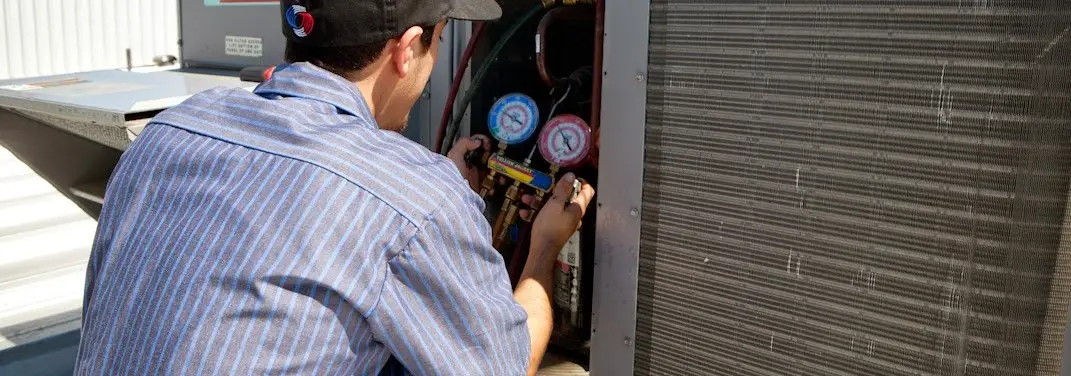 HVAC technician servicing a condenser unit in Moscow